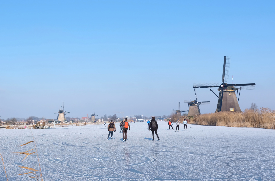 people ice skating near windmills